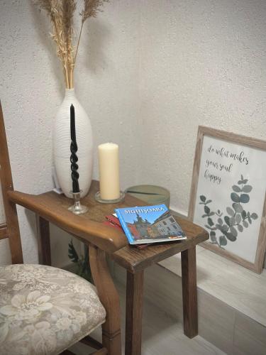 a small wooden table with a vase and a candle on it at CASA 9 in Ferihaza