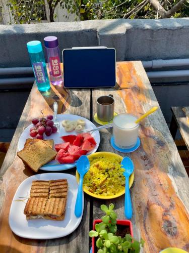 ein Tisch mit einem Teller mit Essen und Löffeln darauf in der Unterkunft Locomo Hostel OG - Stay Work Eat in Mumbai