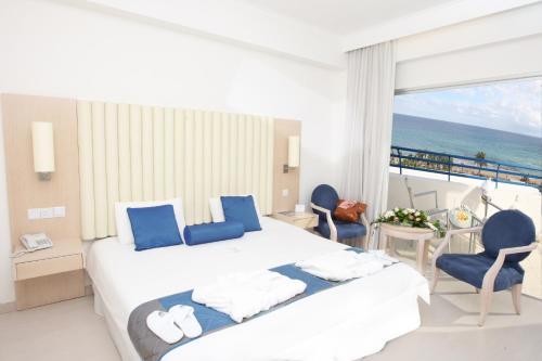 a hotel room with a bed and a view of the ocean at Vrissiana Boutique Beach Hotel in Protaras