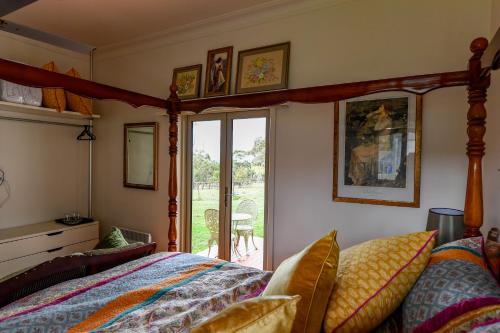 1 dormitorio con 1 cama y puerta de cristal en Galahad's Animal Sanctuary B&B, en Gisborne