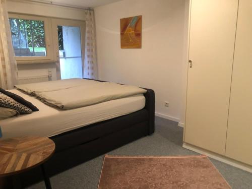 a bedroom with a bed and a table and a window at Ferienwohnung Creutzig in Stockach