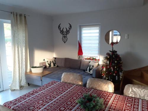 a living room with a couch and a christmas tree at Cisza i Spokój in Szczawnica