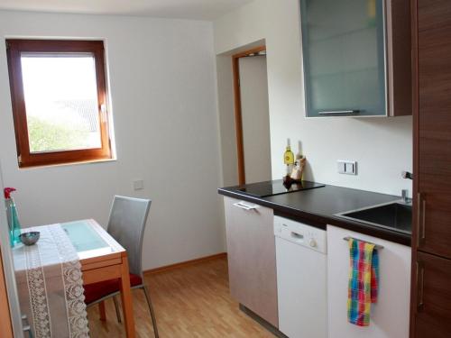 een keuken met een wastafel en een tafel met een raam bij FreiRaum - Wohnen auf Zeit / Wohnung Frederick 