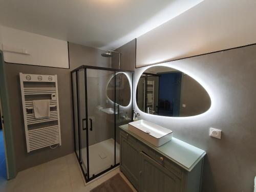 a bathroom with a sink and a shower with a mirror at H de Surgères in Surgères
