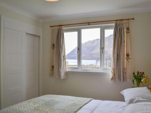 a bedroom with a bed and a window at Invernoe Cottage in Taynuilt