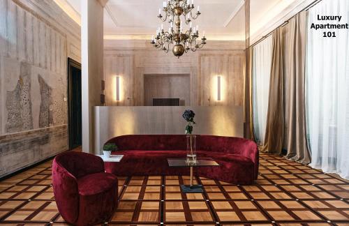 salon z czerwoną kanapą i 2 krzesłami w obiekcie Hotel Pod Różą w Krakowie
