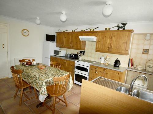 a kitchen with a table and a stove top oven at Coelard Farmhouse in Appin