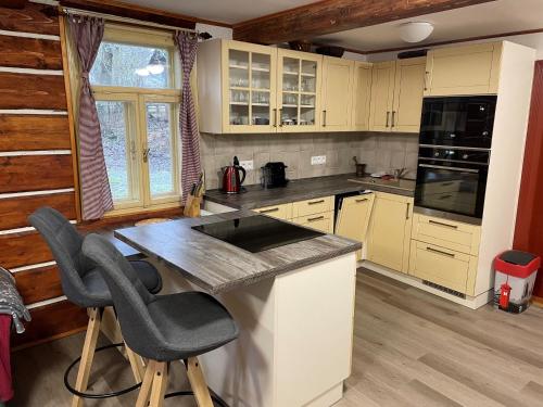 a kitchen with a counter and some chairs in it at Hlinné v Orlických horách in Dobré