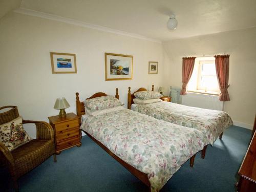 Appin的住宿－科威拉德鄉村別墅，一间卧室设有两张床、一把椅子和一个窗户。