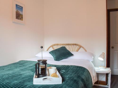 Un dormitorio con una cama con una bandeja de comida. en Primrose Cottage, en Ironbridge