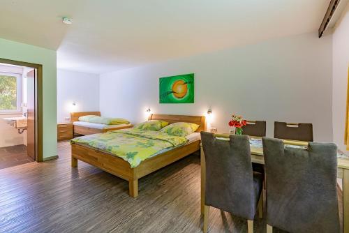 Schlafzimmer mit einem Bett und einem Tisch mit Stühlen in der Unterkunft Pension Berglehner in Bad Griesbach