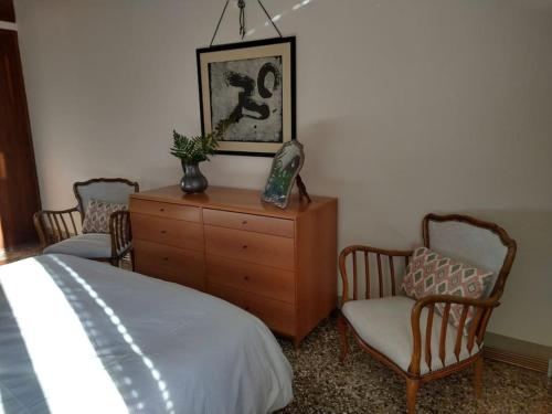アヴィアーノにあるPalazzo Policreti Negrelli Avianoのベッドルーム1室(ドレッサー、椅子2脚、ベッド1台付)