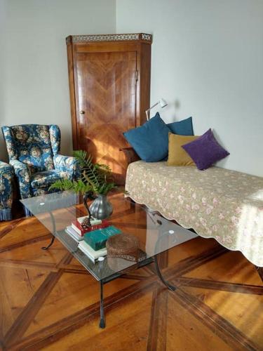 a living room with a couch and a glass table at Palazzo Policreti Negrelli Aviano in Aviano