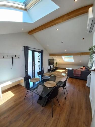 - un salon avec des tables, des chaises et un canapé dans l'établissement Meublé 3* neuf entre lacs, montagnes et bauges., à Mûres-les Balmettes