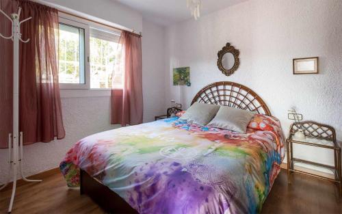 a bedroom with a large bed with a colorful blanket at Xalupa Salions Vistas in Tossa de Mar