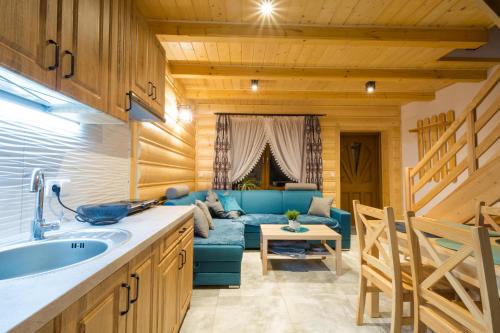 a kitchen and living room with a blue couch at DW KINGA & DOMKI na Granicznej z jacuzzi in Kacwin