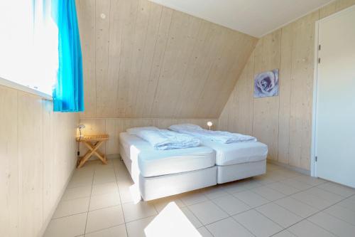 - une chambre avec un lit dans une pièce dotée de murs en bois dans l'établissement Seinpaal, à Callantsoog