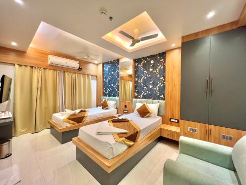 una habitación de hotel con dos camas y un sofá en THE MAGNUM, en Deoghar