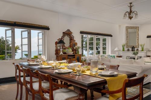 uma sala de jantar com mesa e cadeiras em Highgrove Estate em Labugolla