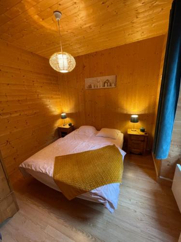 une chambre avec un lit dans une pièce en bois dans l'établissement Appt lumineux centre ville du Mont Dore Vue Sancy, à Le Mont-Dore