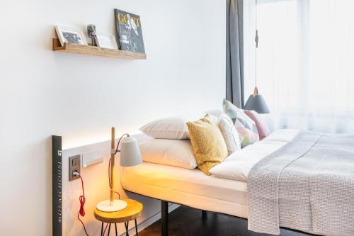 a bedroom with a bed with white sheets and pillows at MOSAIC HOUSE Design Hotel in Prague