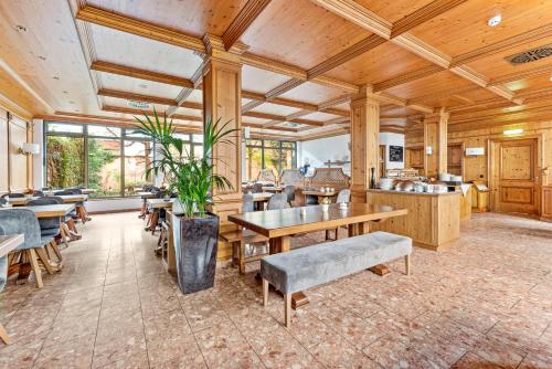 una sala da pranzo con soffitti e tavoli in legno e sedie di King's Hotel Center Superior a Monaco