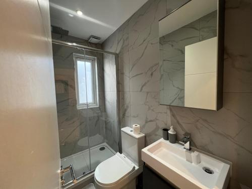 a bathroom with a toilet and a sink and a shower at Star London Station Road 3-Bed Haven in London