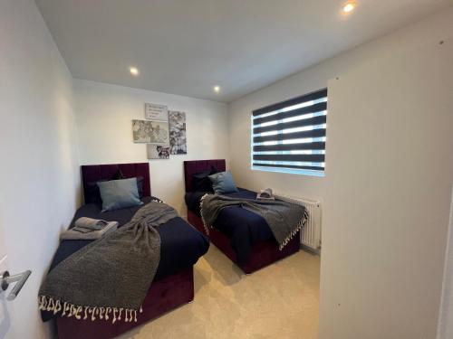 a bedroom with two beds and a window at Star London Station Road 3-Bed Haven in London