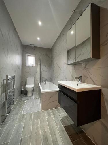 a bathroom with a sink and a toilet at Star London Station Road 3-Bed Haven in London
