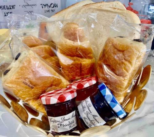 a basket of pastries and jam on a table at ZIN AND ZEN SUPERBE vue SPA SAUNA&JACUZZI in Vitrolles