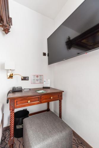 a desk in a room with a lamp and a chair at King's Hotel Center Superior in Munich