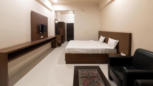 um quarto com uma cama, um sofá e uma televisão em Namastay Welcome Home -Gaya em Gaya