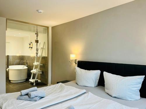 een slaapkamer met een bed en een badkamer met een wastafel bij Ferienwohnung Meeresblick Haus Granitz in Prora in Binz