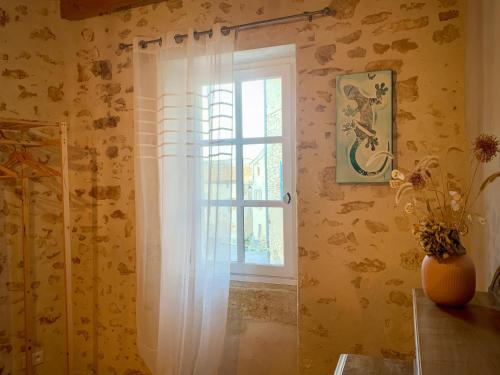 een badkamer met een raam en een douchegordijn bij La Magnanerie de Dions in Dions