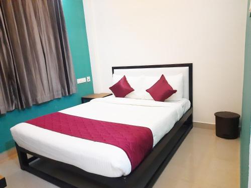 a bedroom with a large bed with red pillows at Hotel Abedrooms- Budget stay Thanjavur in Thanjāvūr