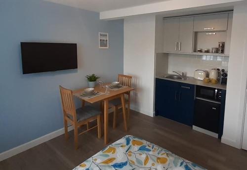 a small kitchen with a table and a dining room at The Studio in Felpham