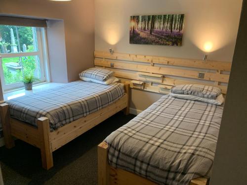 a bedroom with two beds and a window at Tay Bunkhouse in Pitlochry