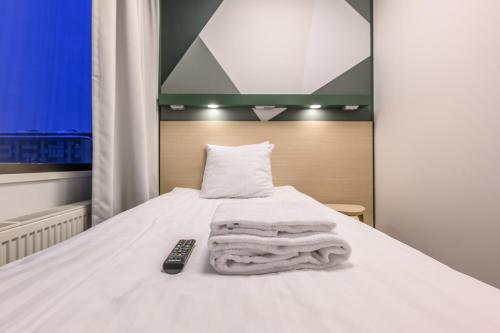 a bed with a remote control sitting on top of it at GreenStar Hotel Oulu in Oulu