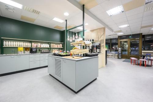 a large kitchen with white cabinets and a counter at GreenStar Hotel Oulu in Oulu