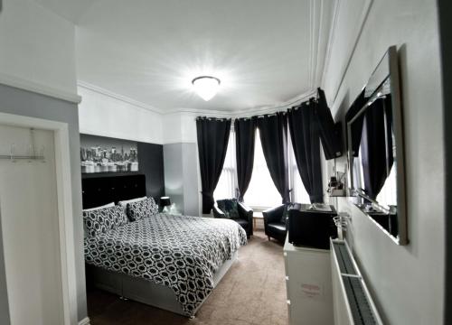 een slaapkamer met een bed en een groot raam bij Rossall House , For Families & Couples in Blackpool