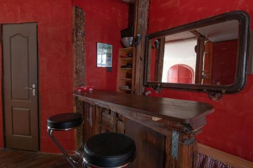 a bar in a room with a mirror and a stool at Cathédrale spacieux appartement in Strasbourg