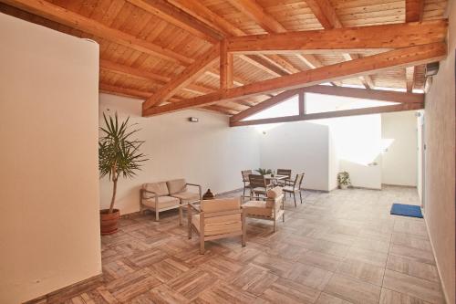a living room with wooden ceilings and a table and chairs at Hotel Muita di Mari in Santa Teresa Gallura