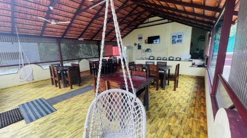 a room with a table and chairs and a swing at Silver springs Homestay Chickmagalur in Chikmagalūr