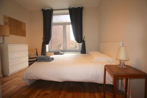 - une chambre avec un grand lit et une fenêtre dans l'établissement Appartement 3 chambres en plein centre ville, à Liège