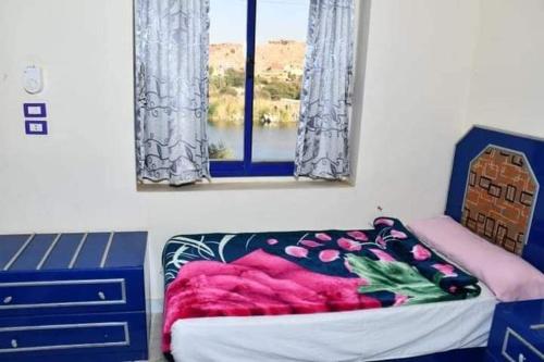 een slaapkamer met een bed en een raam bij شقة للايجار in Aswan