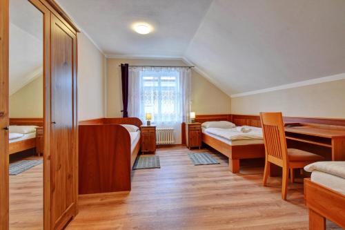 a room with two beds and a table in it at Penzion pod Radyni in Starý Plzenec