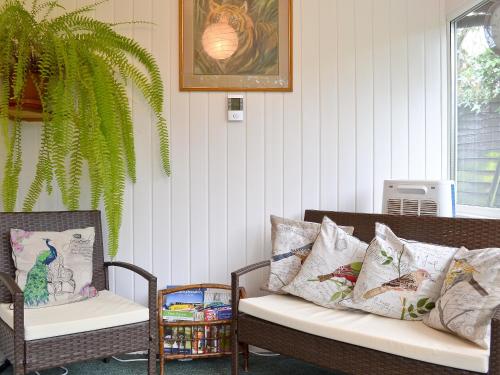 a room with two chairs and a bench with pillows at Brookside in Ellingham