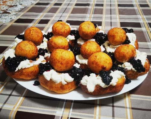 a plate of doughnuts with blueberries and whipped cream at Casa Petran in Breb