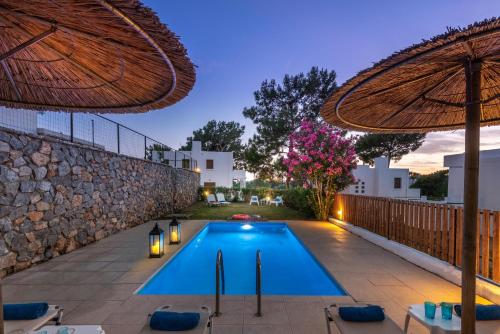 a swimming pool in a backyard with a stone wall at Aggellina Villa in Pefki Rhodes