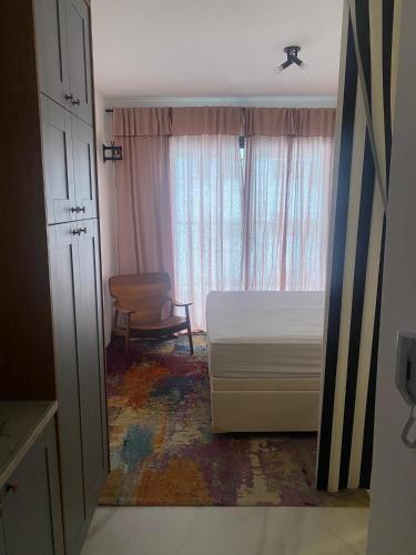 a bedroom with a bed and a window and a chair at São Paulo - Vila Mariana - Central in Sao Paulo